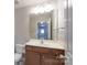 Bright bathroom features a wood vanity, white countertop, updated fixtures, and a mirror at 11922 Kimberfield Rd, Matthews, NC 28105