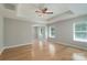 Spacious main bedroom boasts a tray ceiling, ceiling fan, and many windows for ample light at 11922 Kimberfield Rd, Matthews, NC 28105