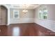 Well-lit dining room with hardwood floors, wainscoting, and a chandelier at 11922 Kimberfield Rd, Matthews, NC 28105