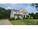 Beautiful two-story home with a well-manicured lawn and a charming front porch at 11922 Kimberfield Rd, Matthews, NC 28105