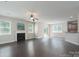 Hardwood floored living room featuring a fireplace, ceiling fan, and access to a kitchen/dining area at 11922 Kimberfield Rd, Matthews, NC 28105