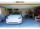 Clean garage with epoxy floors and overhead storage, featuring an electric car at 11965 Hambright Rd, Huntersville, NC 28078