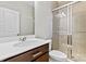 Bathroom with dark wood vanity, single sink and glass enclosed shower at 12205 Hollinhope Dr, Charlotte, NC 28278