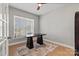 Home office with a sleek black desk, natural light from a large window, and hardwood flooring at 12205 Hollinhope Dr, Charlotte, NC 28278