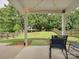 Covered back patio with string lights looking out onto a large fenced backyard and green lawn at 13314 Pontchatrain Ave, Charlotte, NC 28273