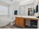 Bathroom featuring a soaking tub, natural light, vanity area, wood-look flooring, and storage at 13314 Pontchatrain Ave, Charlotte, NC 28273