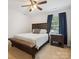 Bedroom with bed, bench, window, side table, and blue curtains with lots of natural light at 13314 Pontchatrain Ave, Charlotte, NC 28273