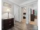 Hallway with wood-look flooring, a dresser, and multiple doorways to bedrooms and other spaces at 13314 Pontchatrain Ave, Charlotte, NC 28273
