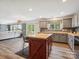 Open kitchen with an island featuring stainless steel appliances and gray cabinetry at 13314 Pontchatrain Ave, Charlotte, NC 28273