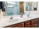 Bathroom featuring double vanity, tile backsplash, large mirror, and shower with glass door at 141 Aberdeen Dr, Troutman, NC 28166