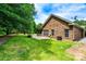 View of the side of the brick home, large yard, and brick patio at 141 Aberdeen Dr, Troutman, NC 28166