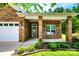 Close-up of the brick home's front entrance with a storm door, porch columns, and manicured landscaping at 141 Aberdeen Dr, Troutman, NC 28166