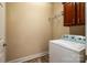 Functional laundry room with washer, overhead storage shelf, and wooden cabinet at 141 Aberdeen Dr, Troutman, NC 28166