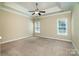 Spacious main bedroom featuring tray ceiling, neutral colors, carpet and natural light from the double windows at 141 Aberdeen Dr, Troutman, NC 28166