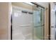 Close-up of walk-in shower featuring grab bar, glass shower door and tile surround at 141 Aberdeen Dr, Troutman, NC 28166