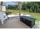 Inviting back patio with a fire pit, grill, and lush greenery for outdoor relaxation and entertaining at 171 Old Harbor Dr, Mount Gilead, NC 27306