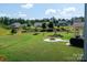 Expansive backyard with lush green grass, mature trees, and a cozy fire pit area at 171 Old Harbor Dr, Mount Gilead, NC 27306