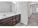 Bathroom with double sink vanity, dark wood cabinets, and view to the hallway for convenience at 171 Old Harbor Dr, Mount Gilead, NC 27306