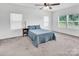 Bright bedroom featuring a ceiling fan, plush carpet, and plentiful natural light from the many windows at 171 Old Harbor Dr, Mount Gilead, NC 27306