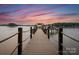 Wooden dock leading to a lake under a vibrant sunset at 173 Rehoboth Ln, Mooresville, NC 28117