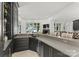 View of the wet bar with gray cabinets and countertops and a fireplace view of the water at 173 Rehoboth Ln, Mooresville, NC 28117