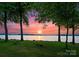Scenic lake view at sunset framed by trees and green lawn at 173 Rehoboth Ln, Mooresville, NC 28117