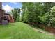 Expansive backyard featuring lush green grass and mature trees, perfect for outdoor activities at 1830 Alden Oaks Ln, Charlotte, NC 28270