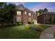 Charming two-story brick home with manicured lawn and mature trees at twilight at 1830 Alden Oaks Ln, Charlotte, NC 28270