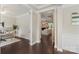Hallway with dark wood floors leading to a study and living room with fireplace at 1830 Alden Oaks Ln, Charlotte, NC 28270