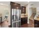 Kitchen with stainless steel refrigerator, dark wood cabinets, and granite countertops at 1830 Alden Oaks Ln, Charlotte, NC 28270