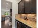 Wet bar in kitchen with granite countertops, wine fridge, and mosaic tile backsplash at 1830 Alden Oaks Ln, Charlotte, NC 28270