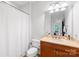 Clean bathroom with a single vanity, toilet and tub with shower curtain at 1903 Kenilworth Ave # 104A, Charlotte, NC 28203