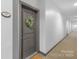Hallway view featuring a gray door with a wreath, neutral carpet, and modern baseboards at 1903 Kenilworth Ave # 104A, Charlotte, NC 28203