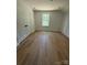 A serene bedroom features hardwood floors, a double closet, and a window view of trees at 1923 Fairfield Rd, Mount Gilead, NC 27306
