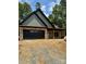 Newly constructed home with stone accents, a black garage door, and copper-colored gutters at 1923 Fairfield Rd, Mount Gilead, NC 27306