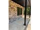 A covered porch is adorned with stacked stone, sleek windows, and dark stained wooden posts at 1923 Fairfield Rd, Mount Gilead, NC 27306