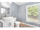 Powder room features a sleek, modern sink and vanity beneath a round mirror, plus a large window at 1925 Montclair Ave, Gastonia, NC 28054