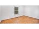 Bright, empty bedroom with wood floors and a window dressed with blinds for privacy and light control at 1925 Montclair Ave, Gastonia, NC 28054