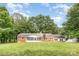 Charming brick home with a screened-in porch and lush green lawn under a beautiful blue sky at 1925 Montclair Ave, Gastonia, NC 28054