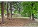 Brick home nestled among mature shade trees, lawn and landscaped shrubs at 1925 Montclair Ave, Gastonia, NC 28054
