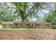 Charming brick home featuring lush landscaping, mature trees and a welcoming entrance at 1925 Montclair Ave, Gastonia, NC 28054