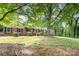 Traditional brick home with shade trees, level lawn, and manicured shrubs at 1925 Montclair Ave, Gastonia, NC 28054