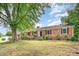 Well-maintained brick home showcasing traditional architecture, manicured shrubs and an established lawn at 1925 Montclair Ave, Gastonia, NC 28054