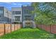 Fenced backyard featuring a lush lawn, small balcony, and a wooden fence for privacy at 209 Keswick Ave, Charlotte, NC 28206