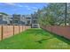 Large, well-manicured backyard featuring new construction homes, a privacy fence, and ample green space at 209 Keswick Ave, Charlotte, NC 28206