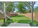 Large fenced-in backyard with green grass, stairs, brick, and wood features at 209 Keswick Ave, Charlotte, NC 28206