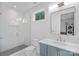 Modern bathroom with glass enclosed shower, grey tile, and sleek blue vanity at 209 Keswick Ave, Charlotte, NC 28206