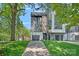 Contemporary two-story home with a gray and white exterior, attached garages, and manicured lawn at 209 Keswick Ave, Charlotte, NC 28206