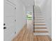 Hallway with hardwood floors, white walls, stairs with wooden treads and black banister and a view of the backyard at 209 Keswick Ave, Charlotte, NC 28206