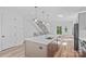 Open kitchen with island, modern appliances, view to the living room, and access to stairs at 209 Keswick Ave, Charlotte, NC 28206
